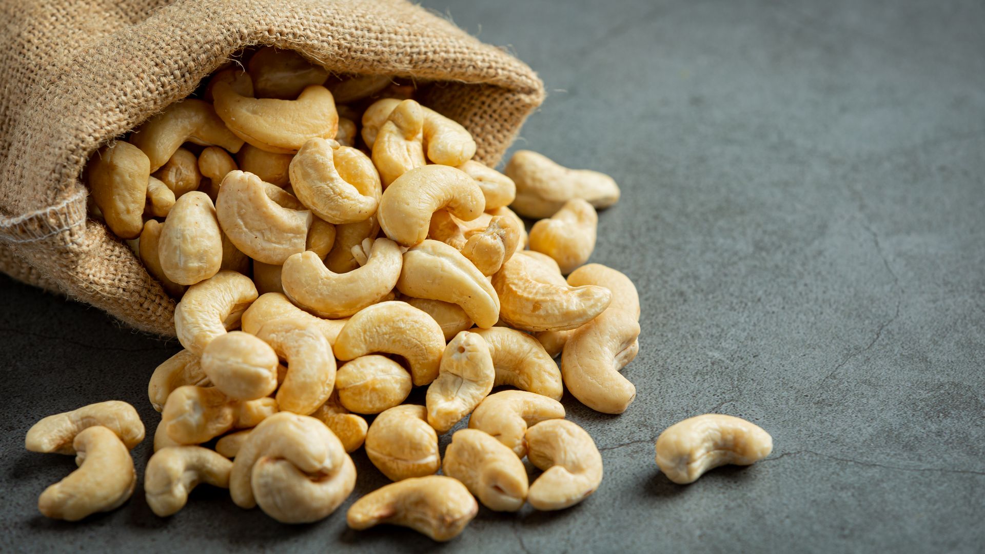 Cashew kernels spilling from a jute sack